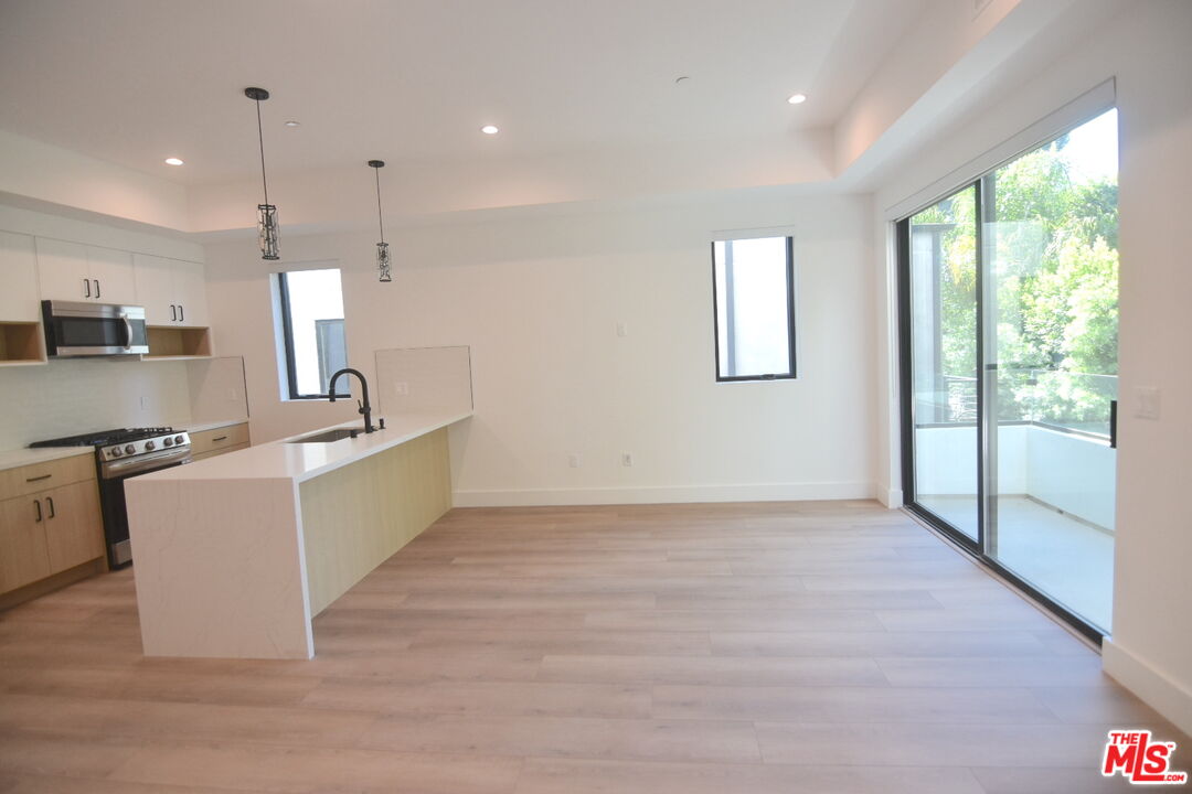 a large kitchen with kitchen island a counter top space appliances and a window