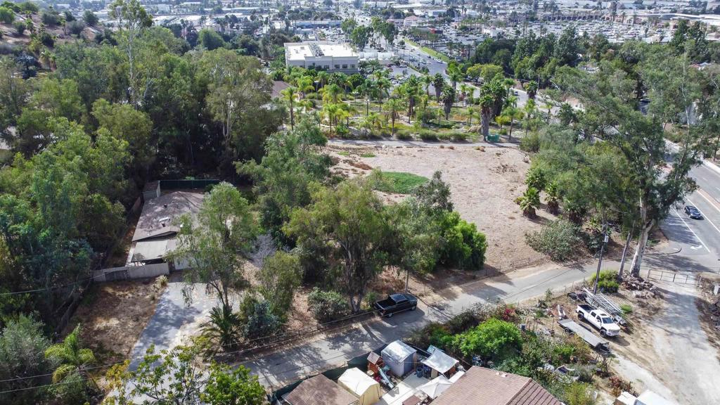 an aerial view of residential house with outdoor space and trees all around