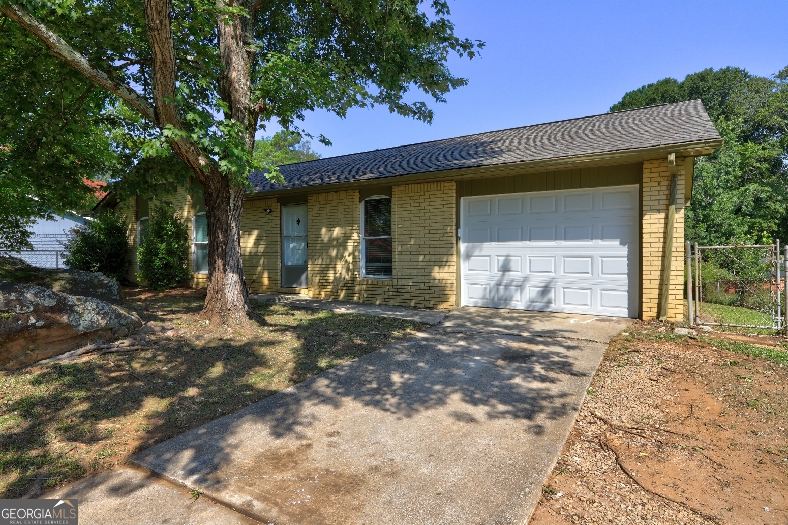 a front view of a house with a tree