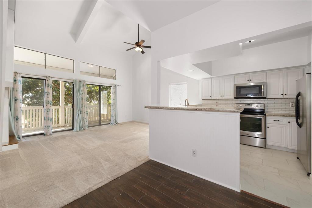 a view of a kitchen with wooden floor and electronic appliances