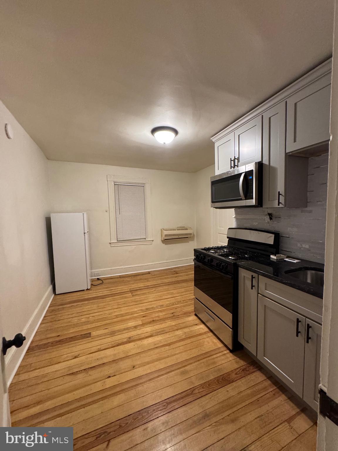 a kitchen with granite countertop a stove top oven and cabinets