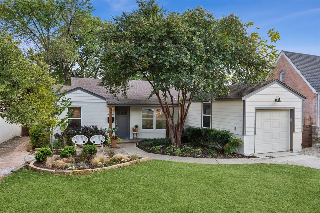 a view of a house with a yard and potted plants