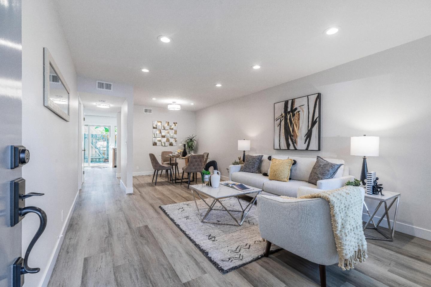 a living room with furniture a wooden floor and a chandelier