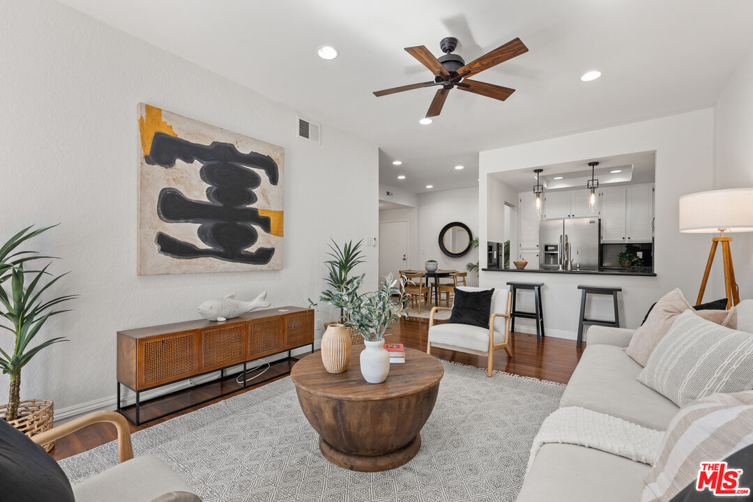 a living room with furniture and view of kitchen