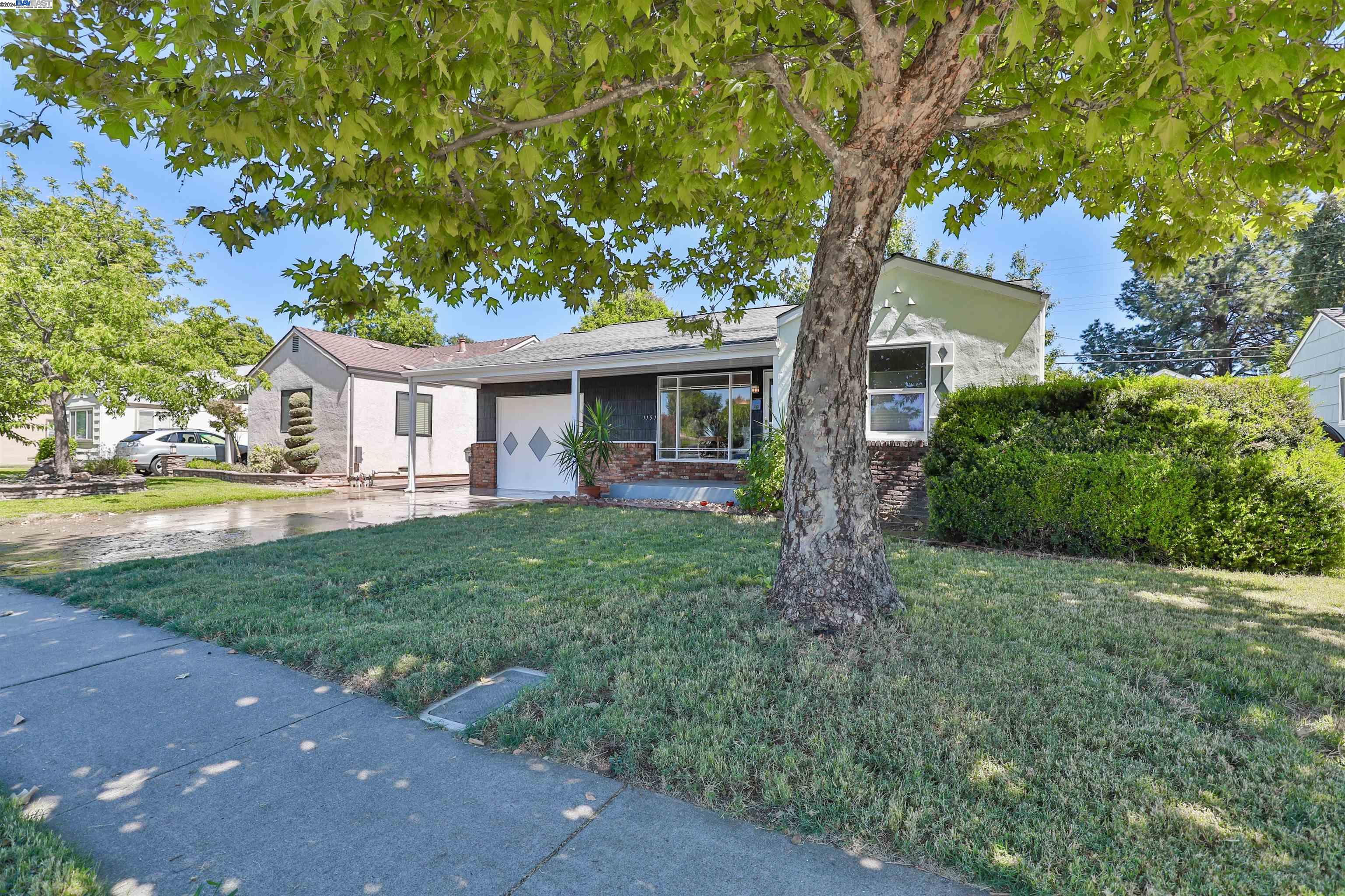 a front view of a house with a yard and green space