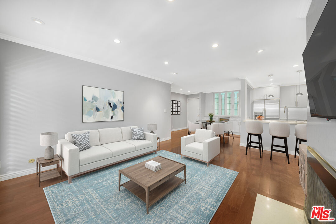 a living room with furniture and a dining table with wooden floor