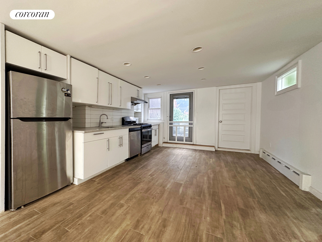 a view of kitchen with stainless steel appliances wooden floor and cabinets