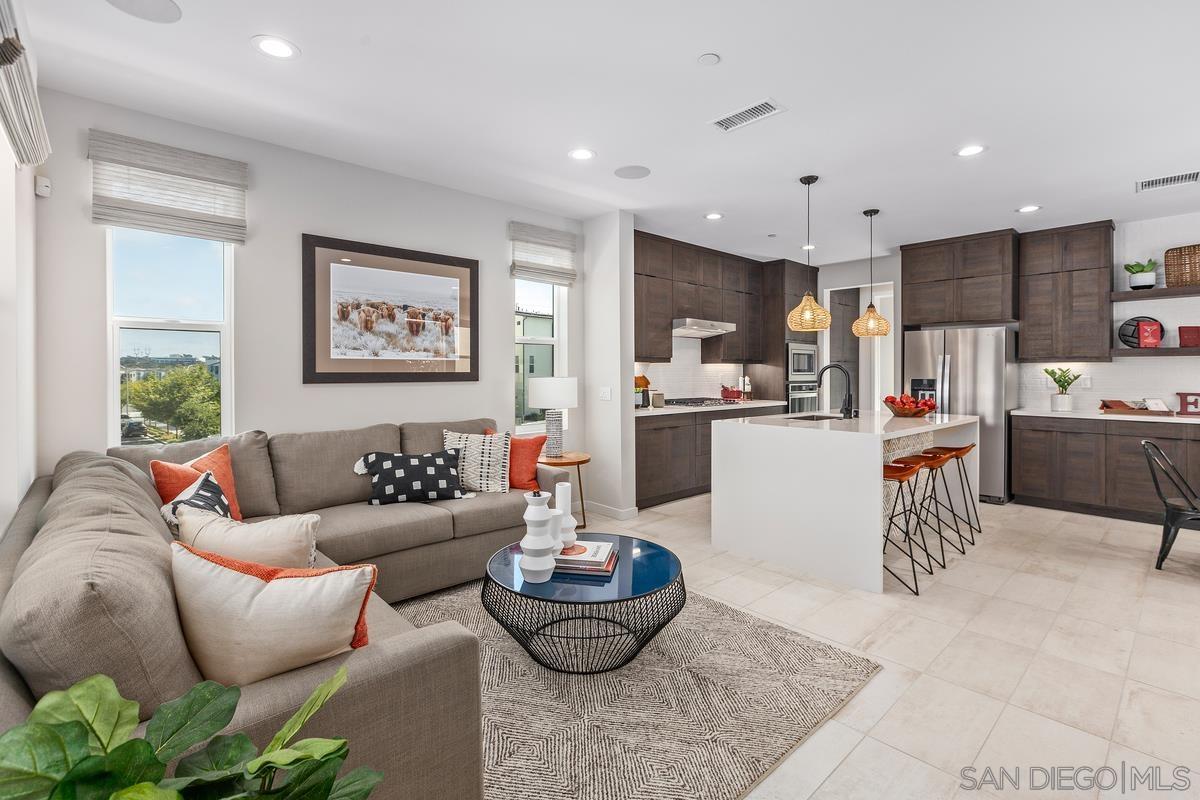 a living room with furniture and kitchen view