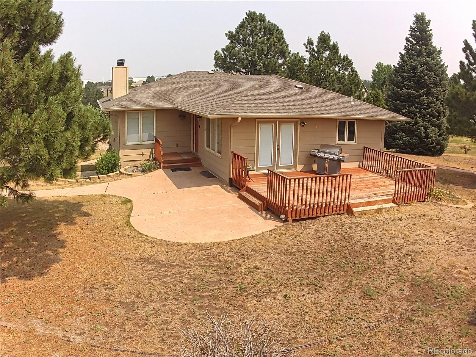 a view of a house with backyard and sitting area