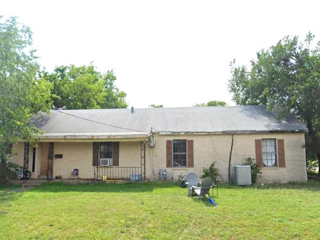 a front view of a house with a yard and trees