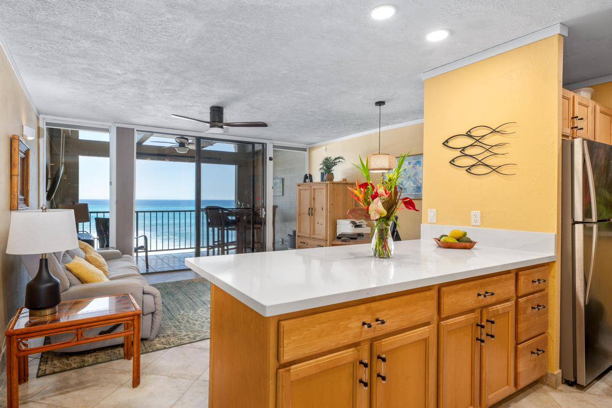 a living room with stainless steel appliances granite countertop furniture and a large window