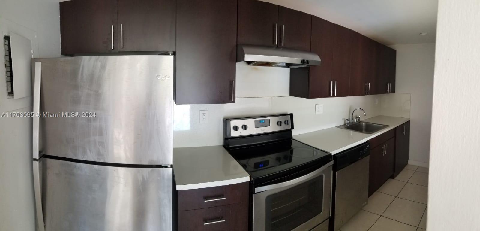 a kitchen with stainless steel appliances a refrigerator and a stove top oven