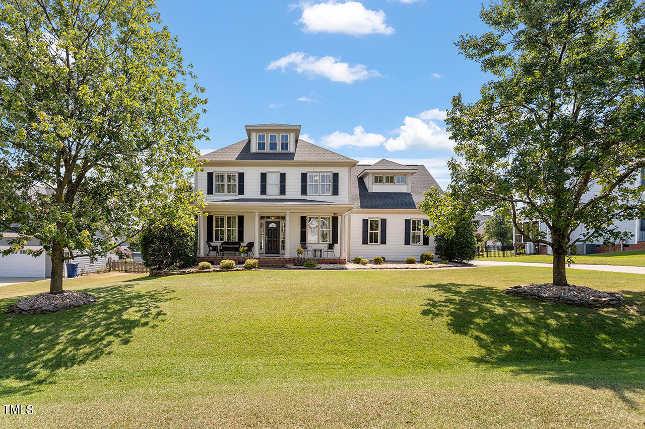 a view of a house with a big yard and large trees