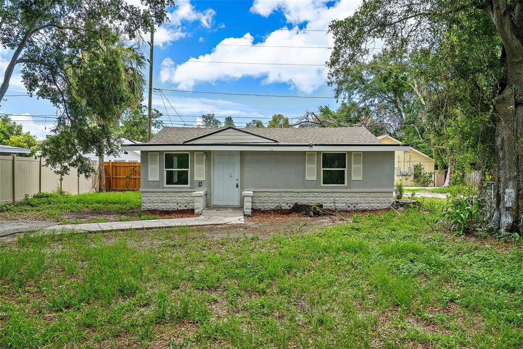 a front view of a house with a yard and trees