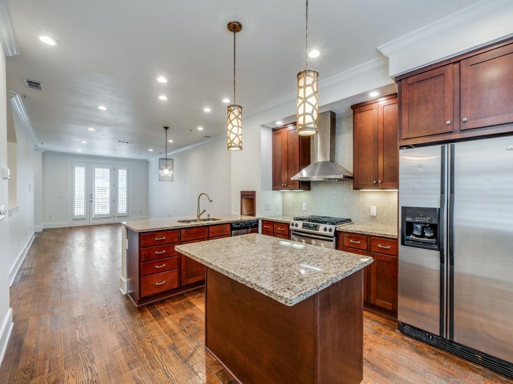 a kitchen with stainless steel appliances granite countertop a sink a stove and a refrigerator