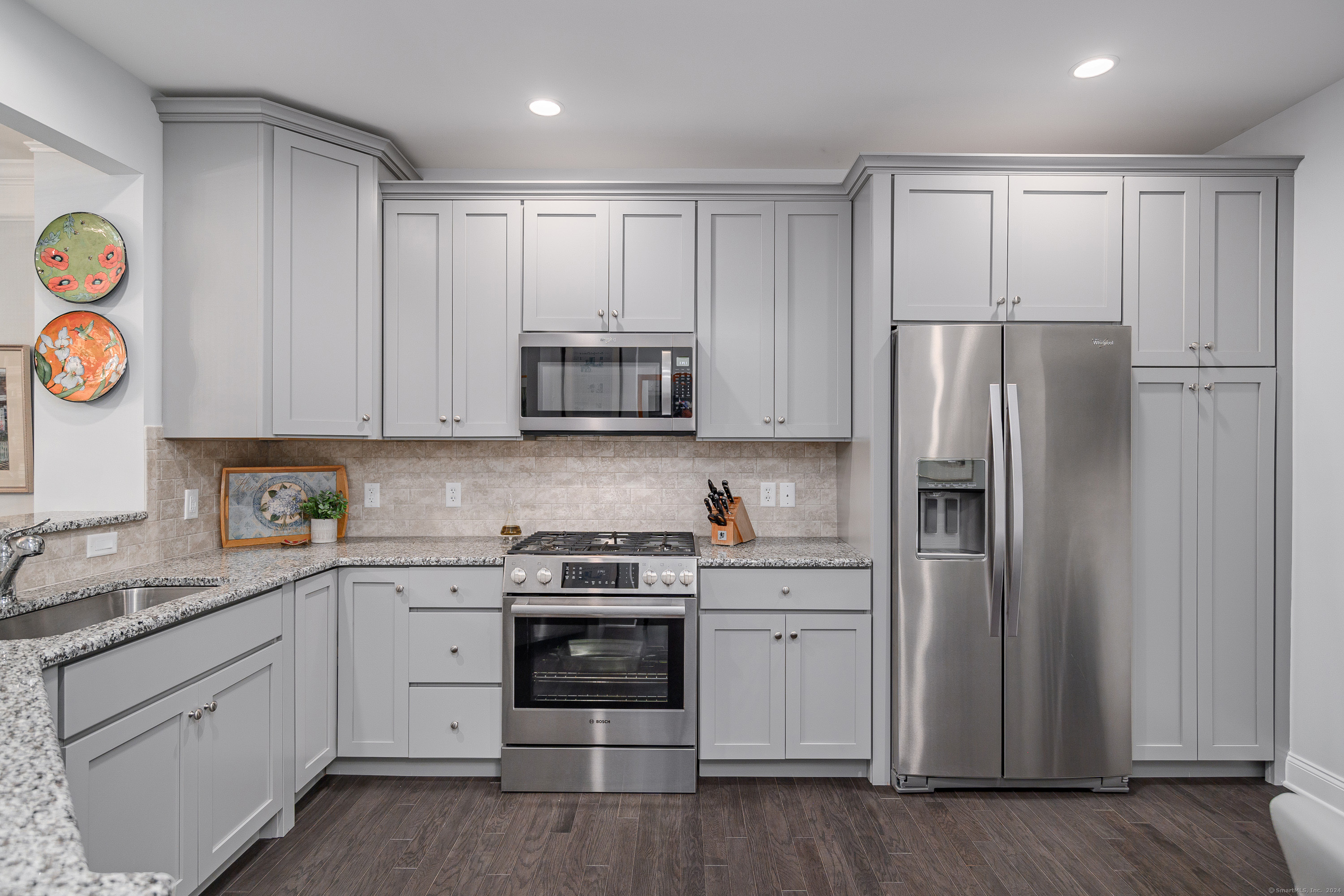 a kitchen with stainless steel appliances granite countertop a refrigerator and a stove top oven