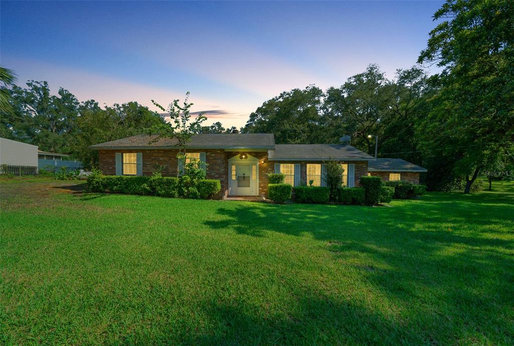 a front view of a house with a yard porch and garden