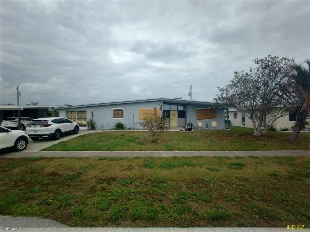 Ranch-style home featuring a front lawn