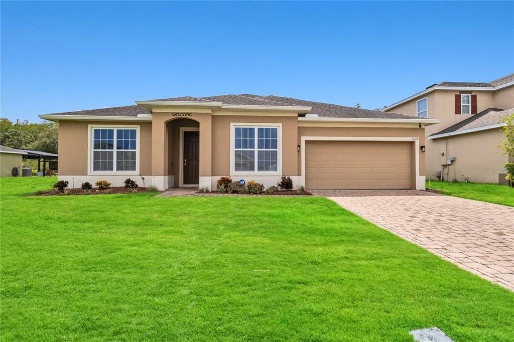 a front view of a house with a garden and yard