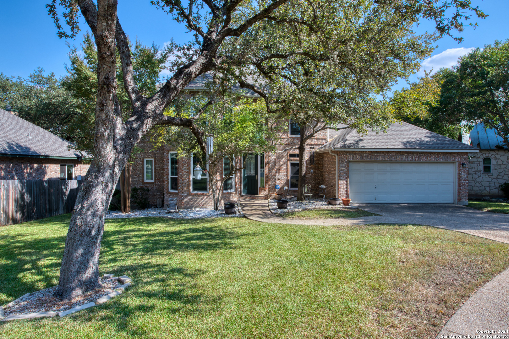 a view of a house with backyard and a tree