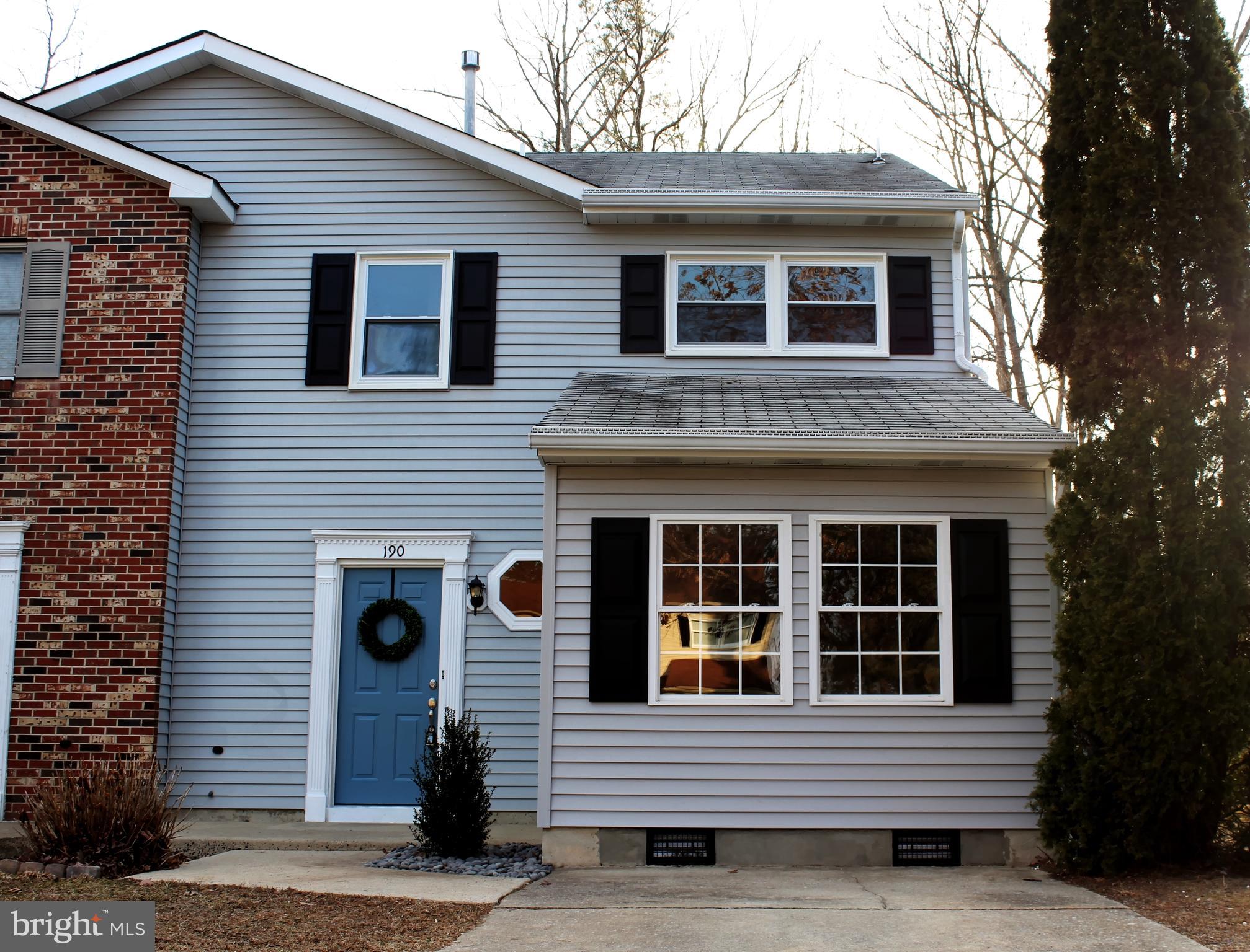 a view of front of a house with a yard and large tree