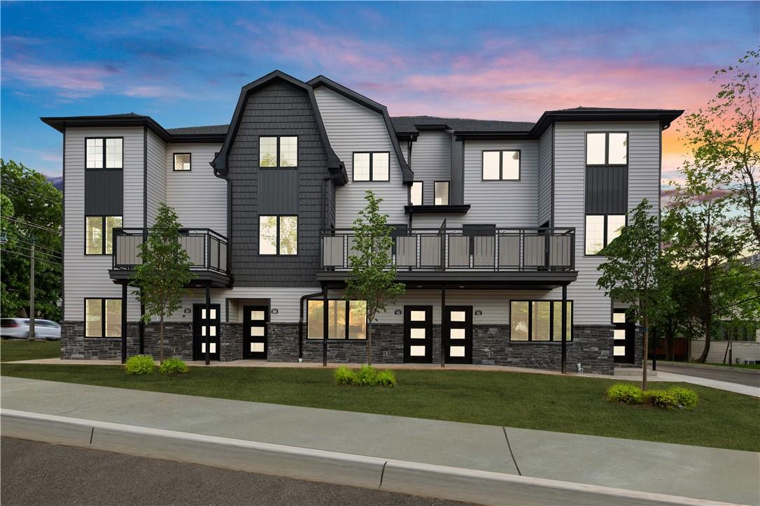 View of front of home featuring a balcony and a lawn