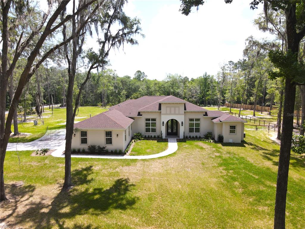 a view of a house with pool and a yard