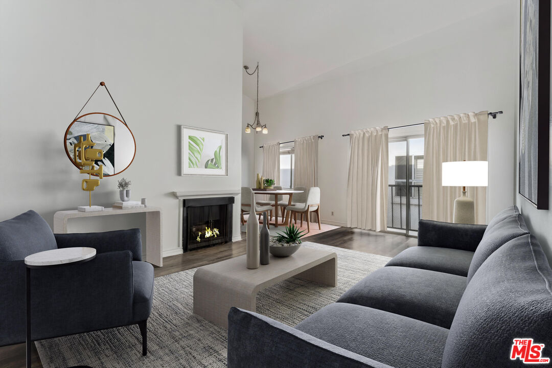 a living room with furniture a fireplace and a large window