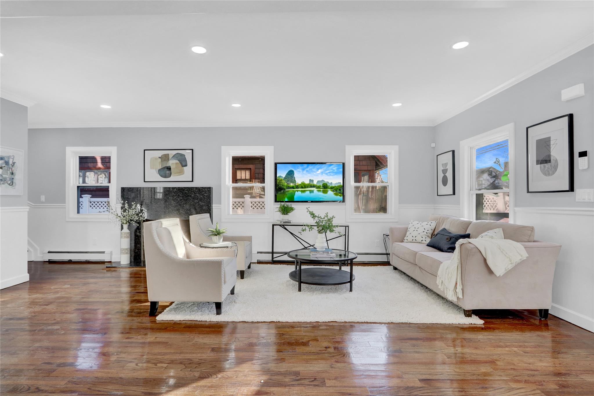 Living room featuring crown molding, wood-type flooring, and a baseboard radiator