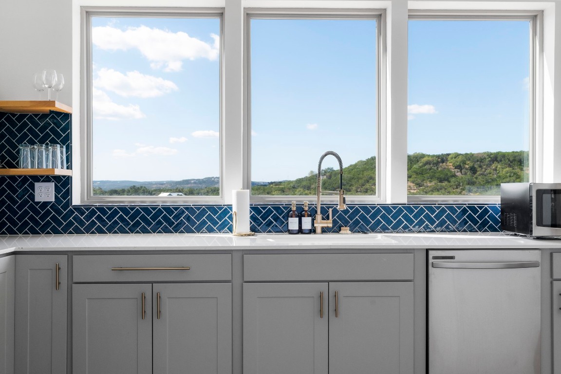 a kitchen with stainless steel appliances granite countertop a coffee maker next to a window