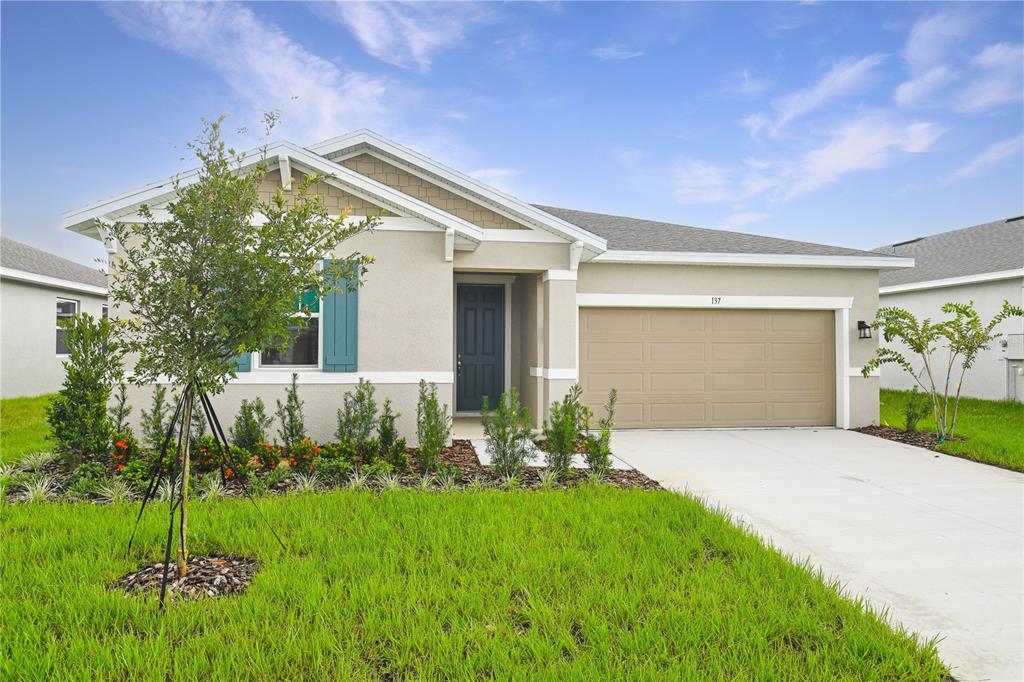 a front view of a house with a yard and garage