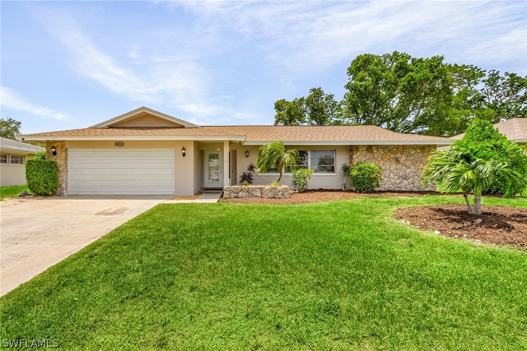 a front view of a house with a yard and green space