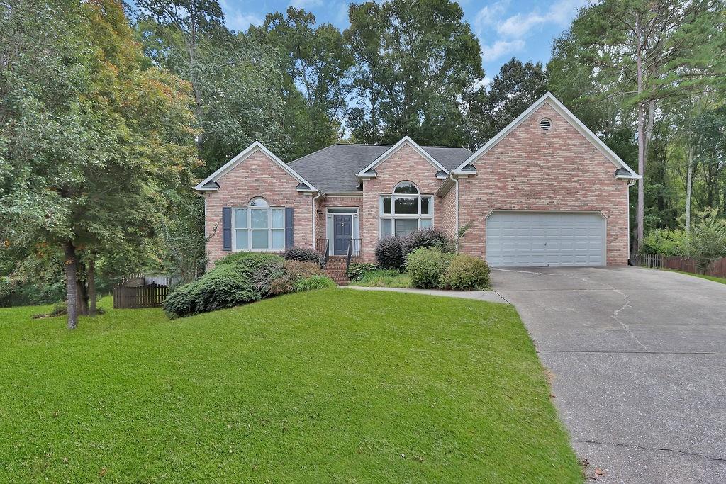 a front view of a house with a yard and trees