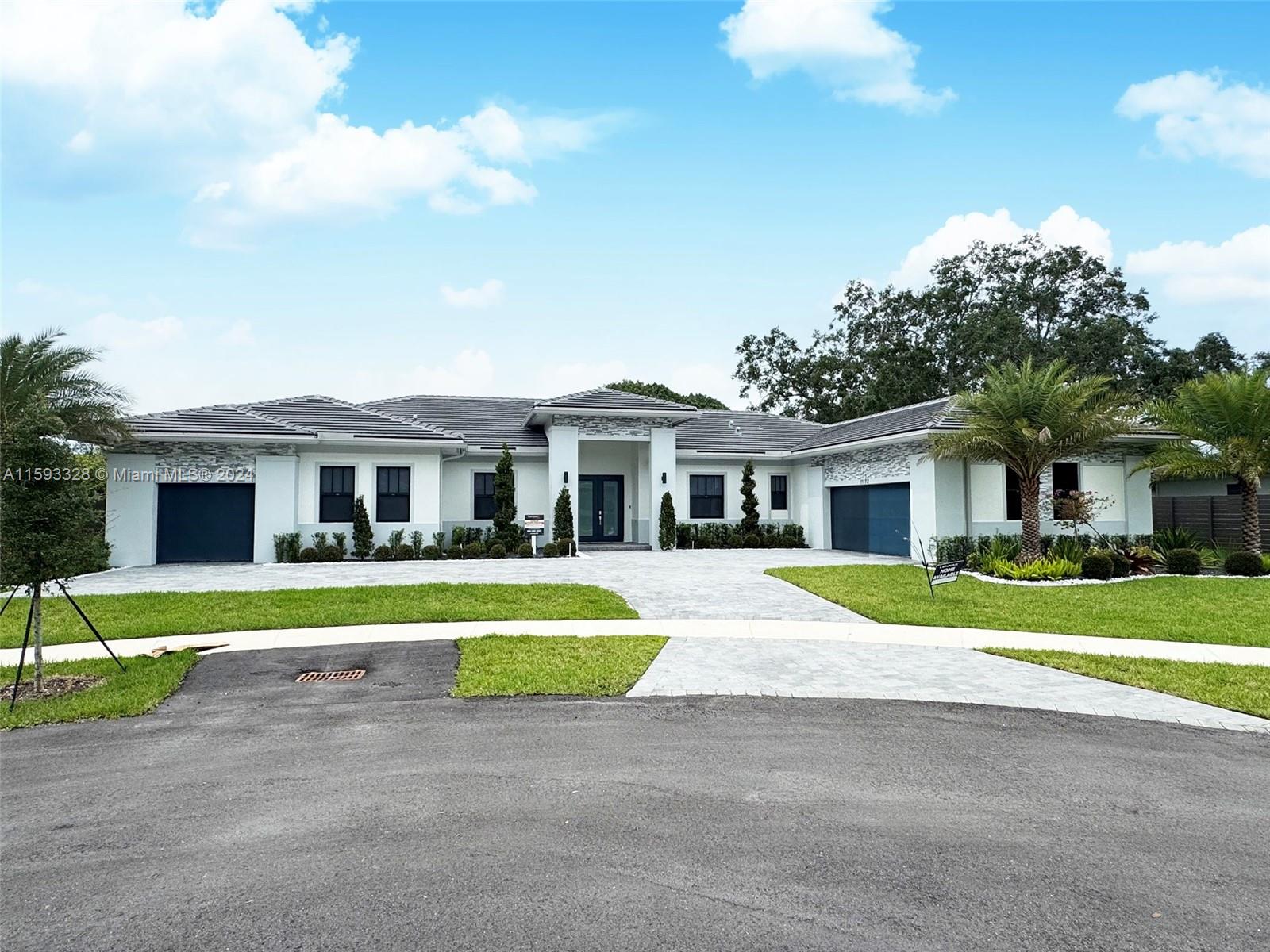 a front view of a house with a yard and trees