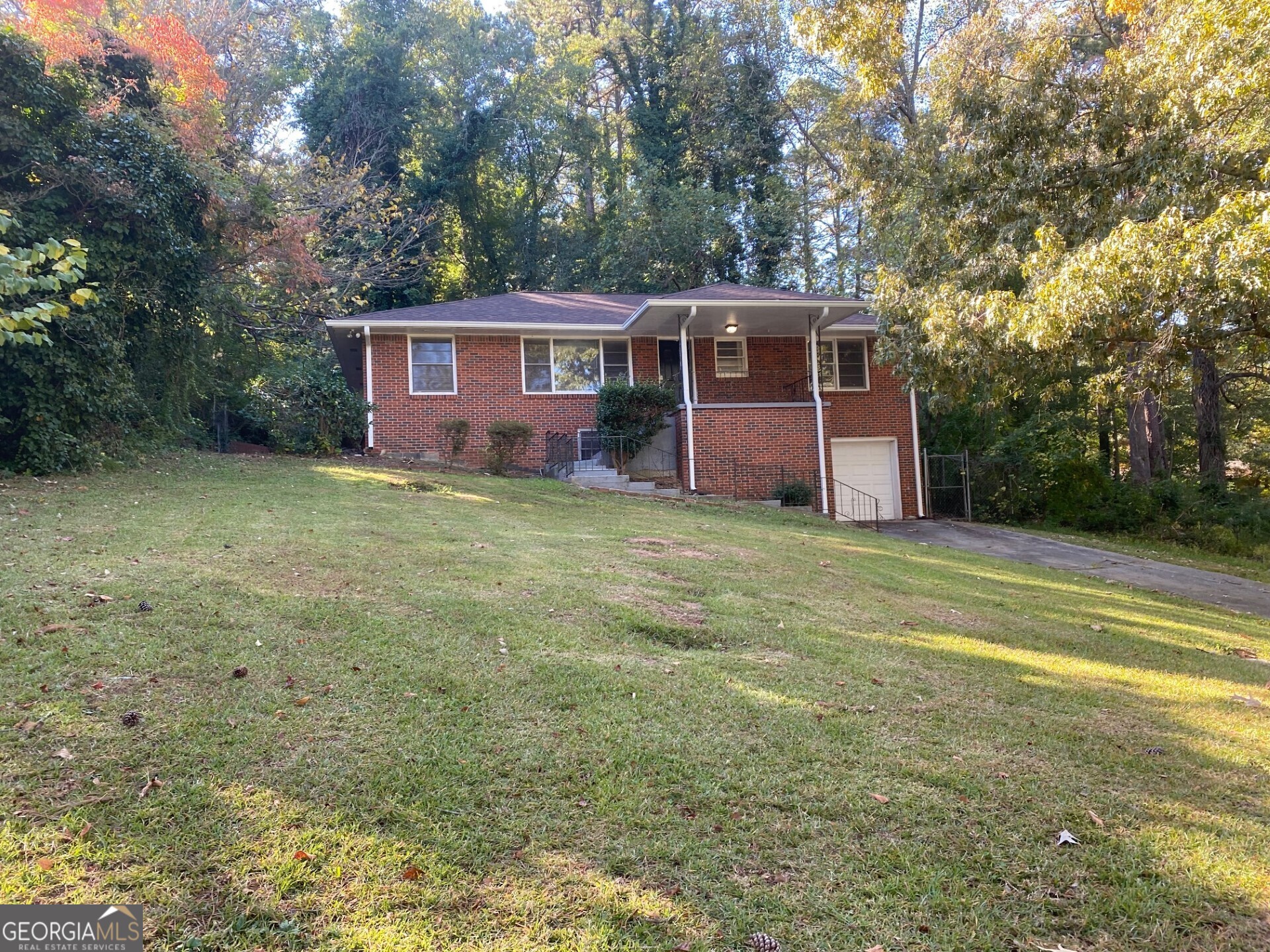 a view of a yard in front of a house with large trees