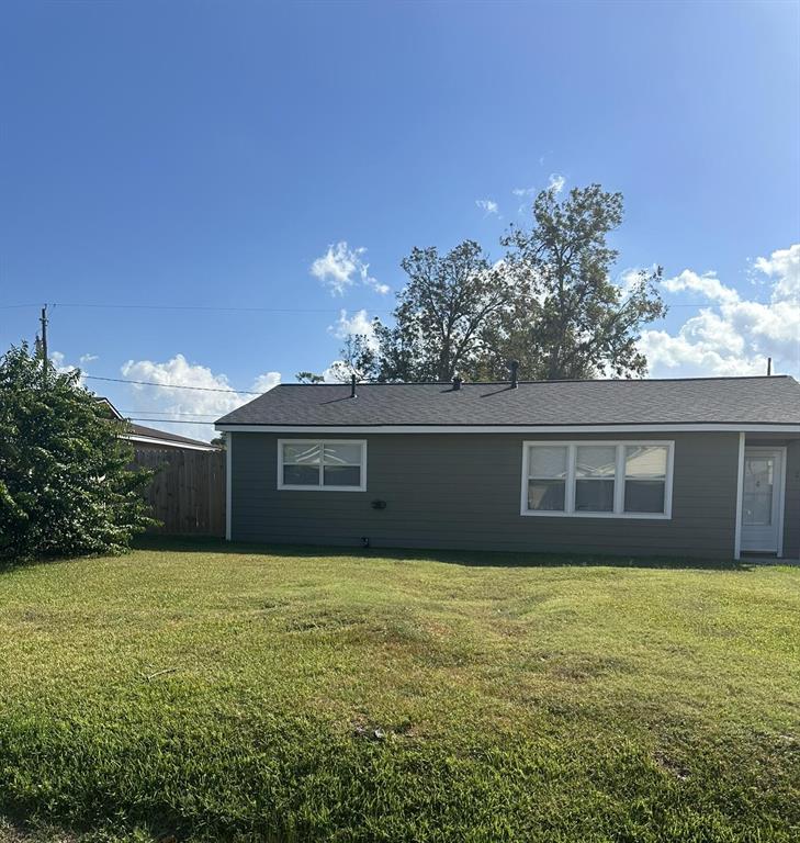 a front view of house with yard and trees in the background