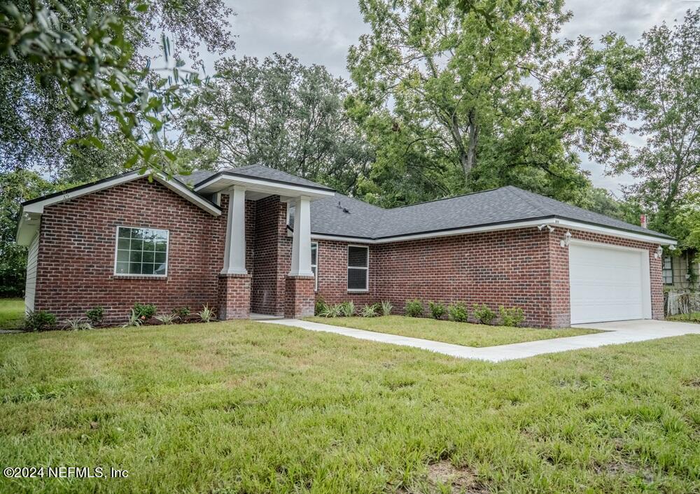 a front view of house with yard and trees all around