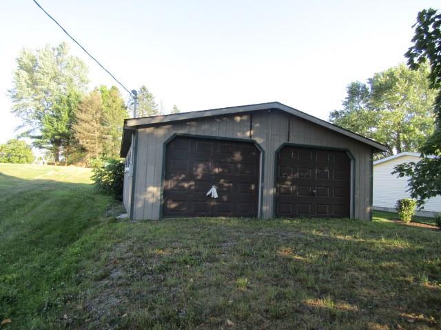 a view of a house with yard and a garage