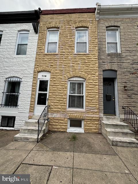 a view of a house with a bench in front of door