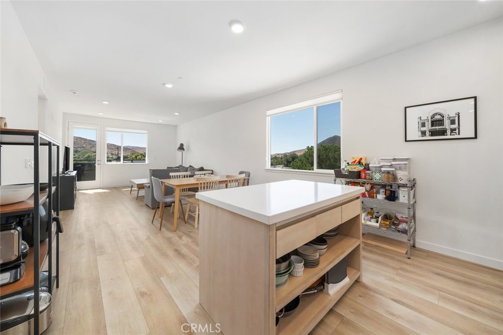 a living room with stainless steel appliances furniture a rug and a table