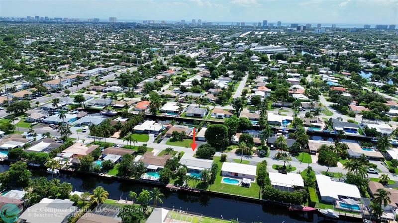 an aerial view of residential houses with outdoor space and trees