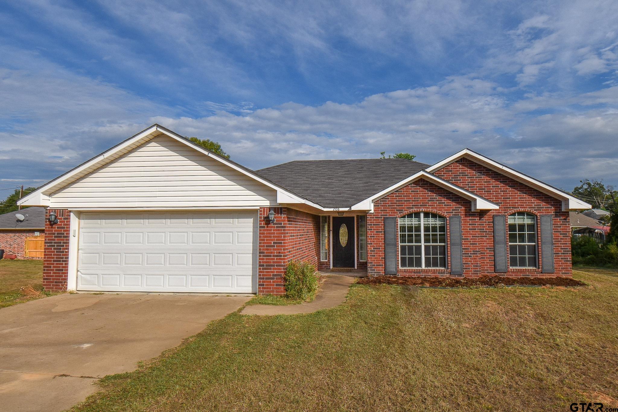 a view of a house with a yard and garage