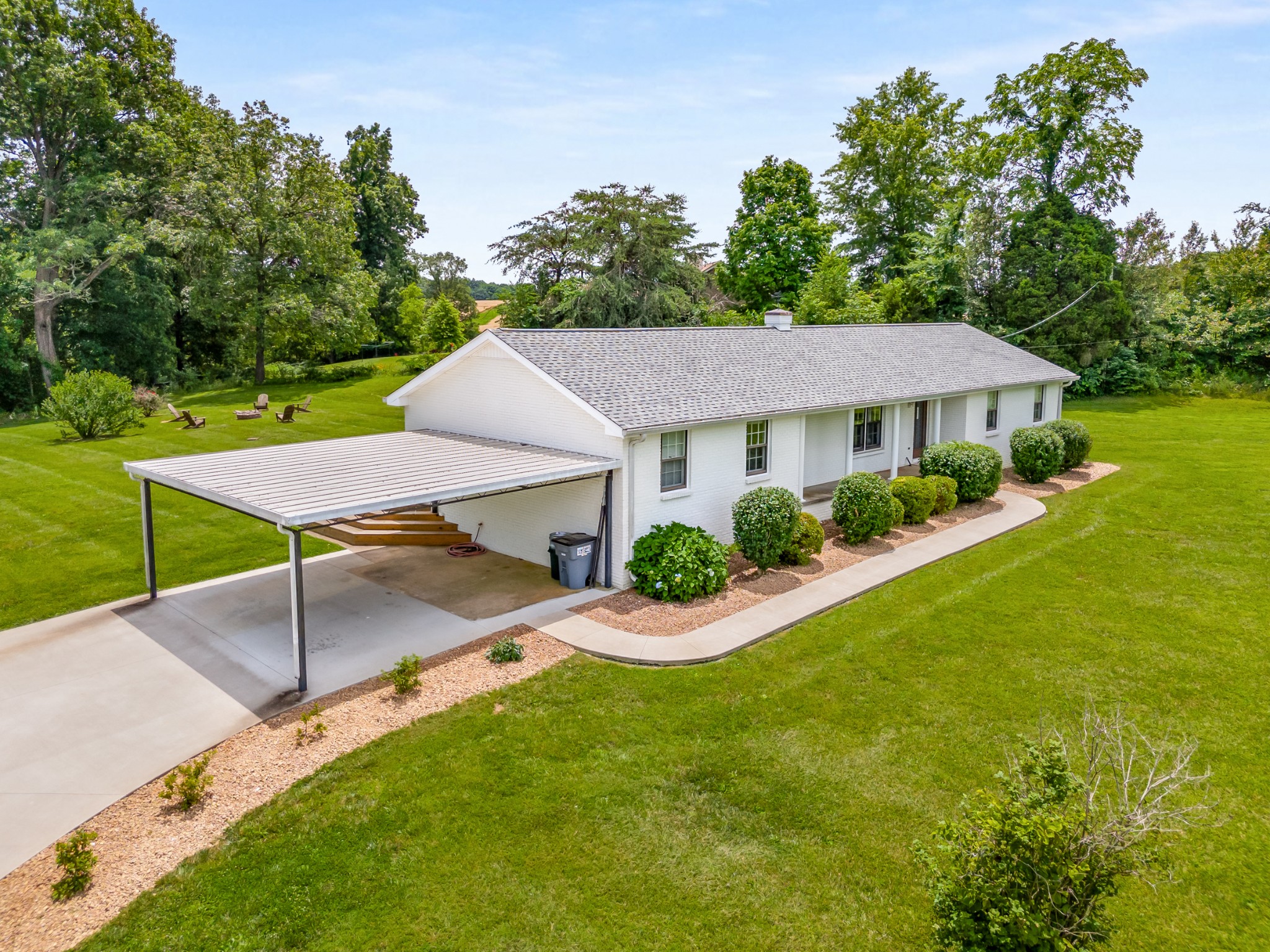 a aerial view of a house with table and chairs under an umbrella