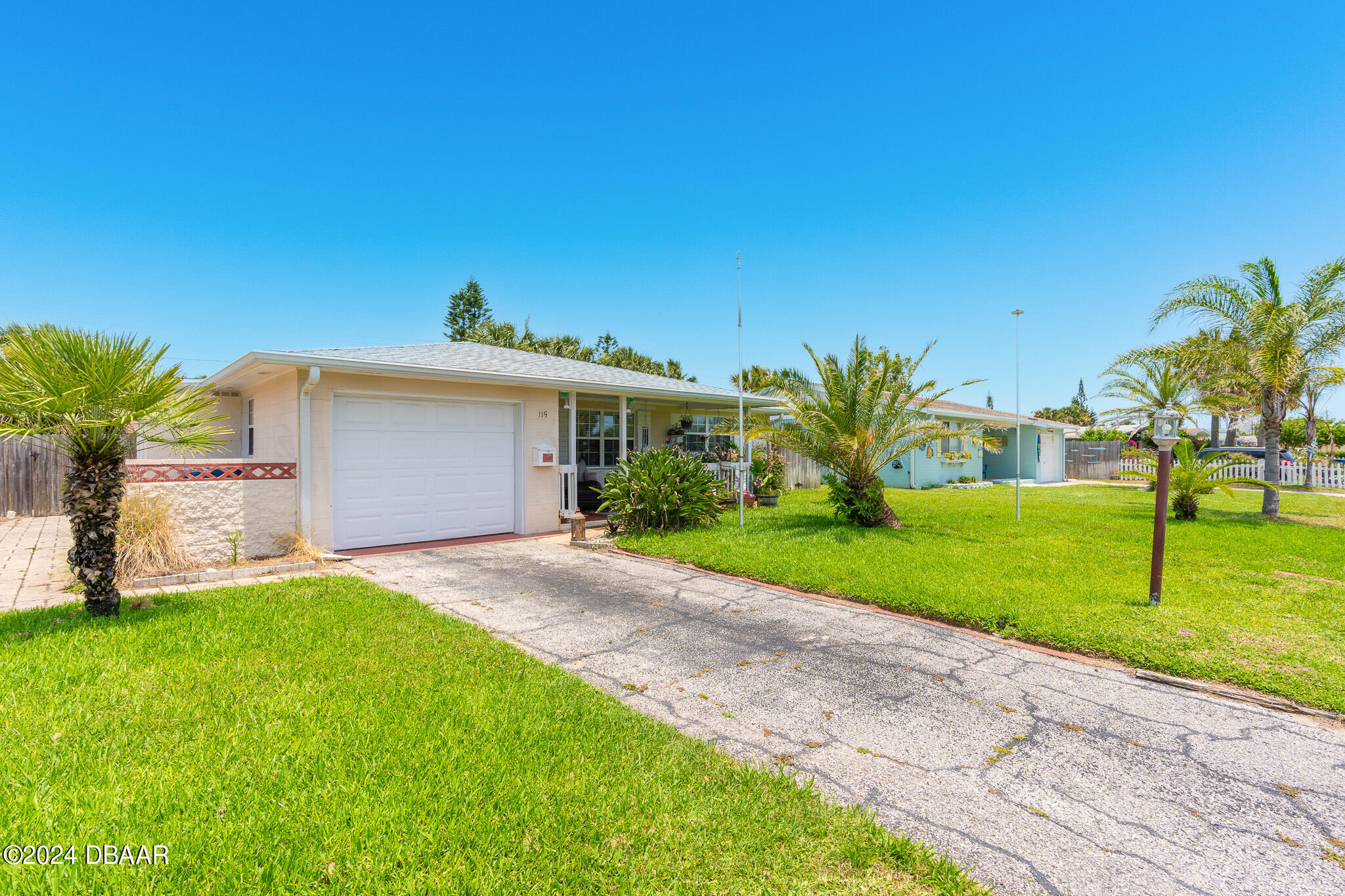 a view of a house with a yard and palm tree