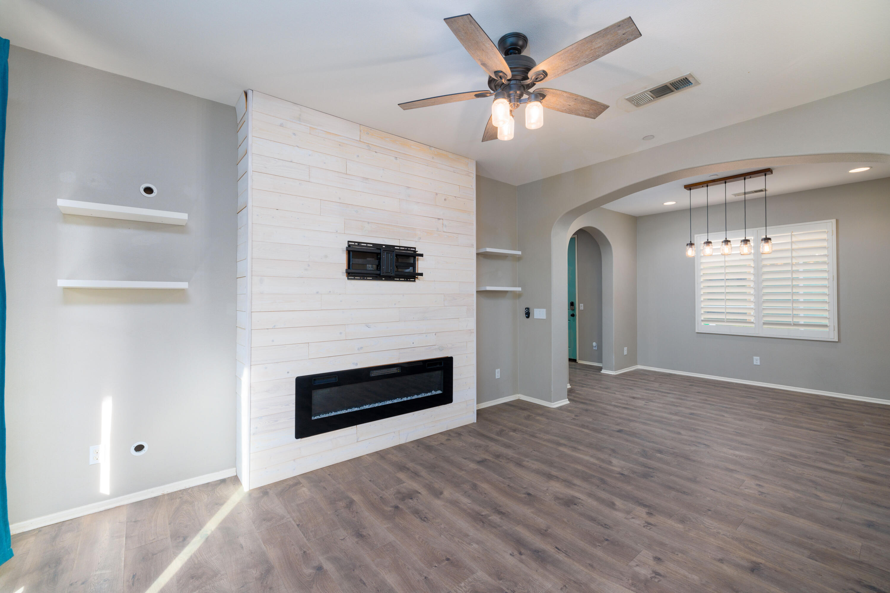 a view of an empty room with a fireplace and a window