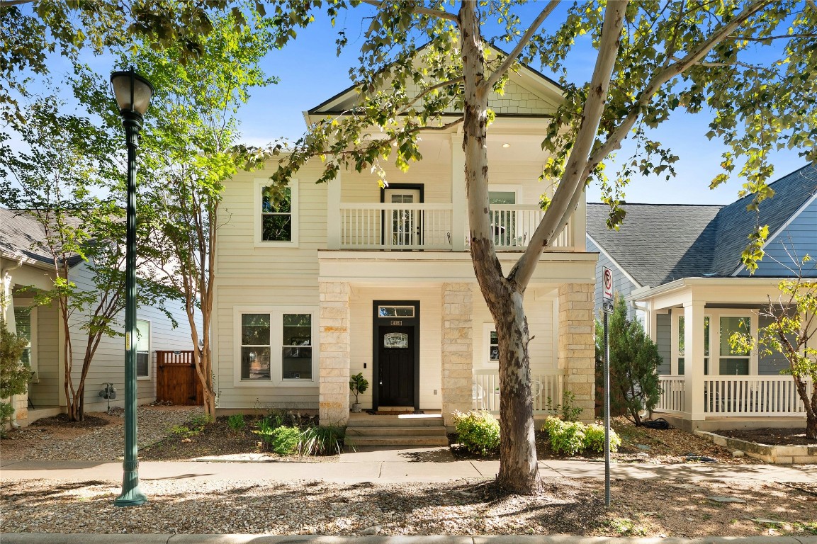 a front view of a house with a tree