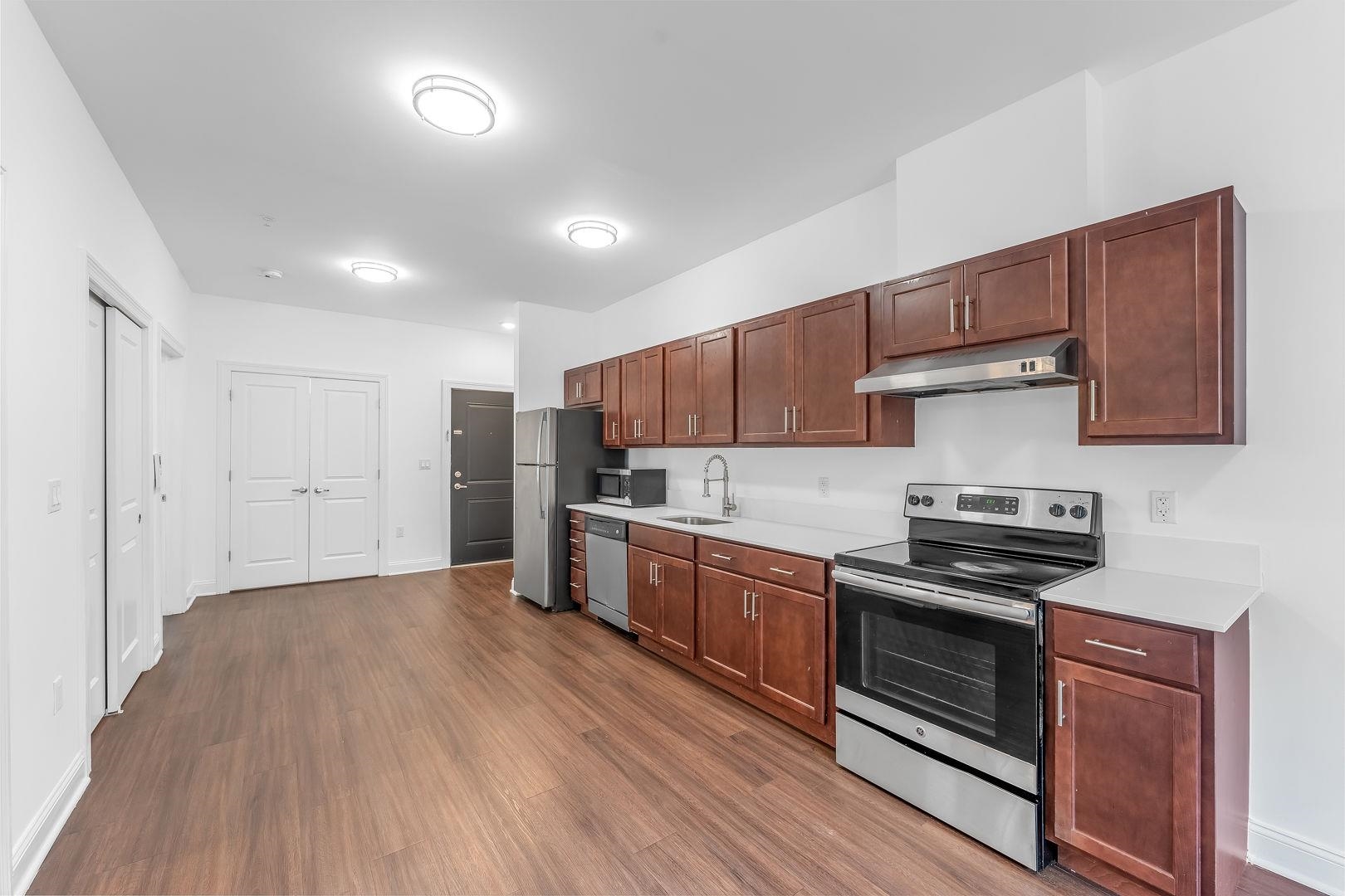 a kitchen with granite countertop wooden floors and stainless steel appliances