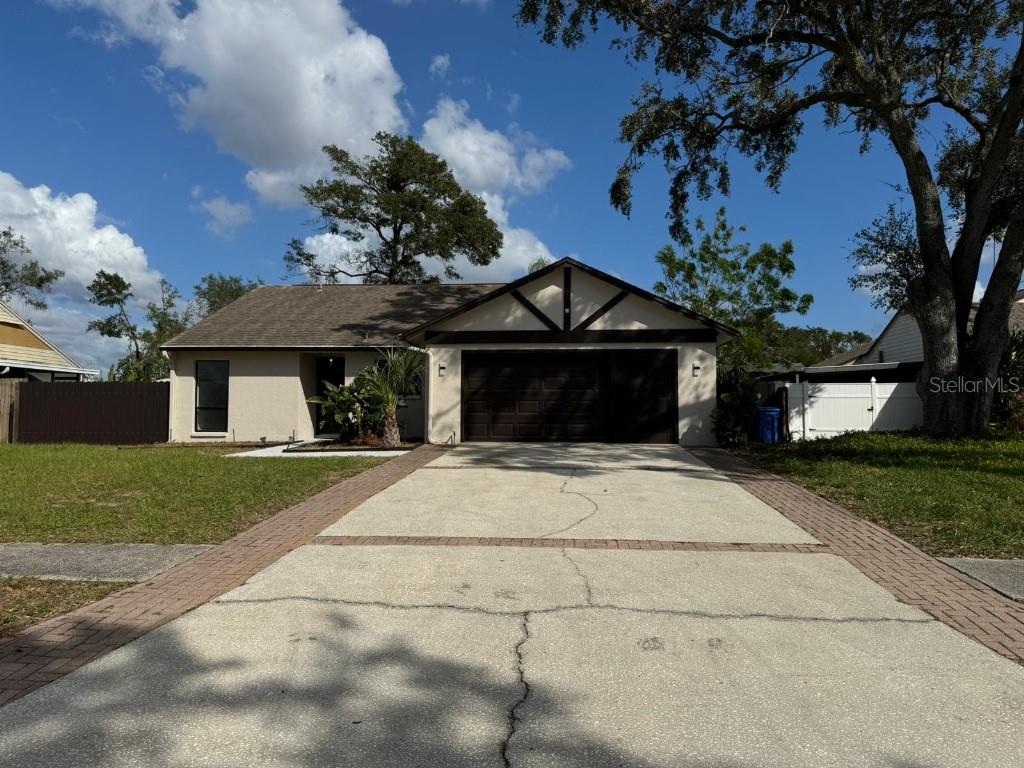 a front view of a house with a garden and trees