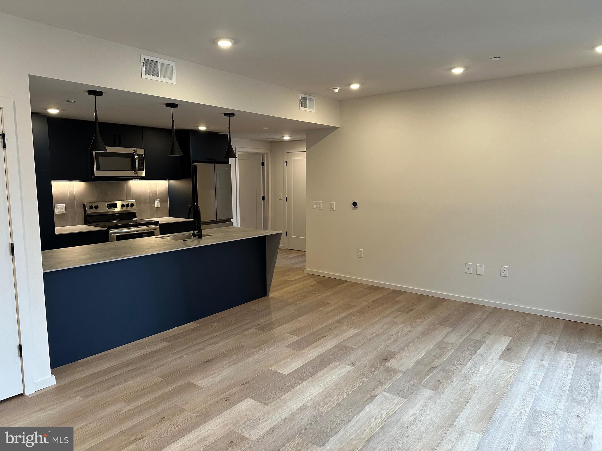 a kitchen with stainless steel appliances kitchen island granite countertop a refrigerator and a stove top oven