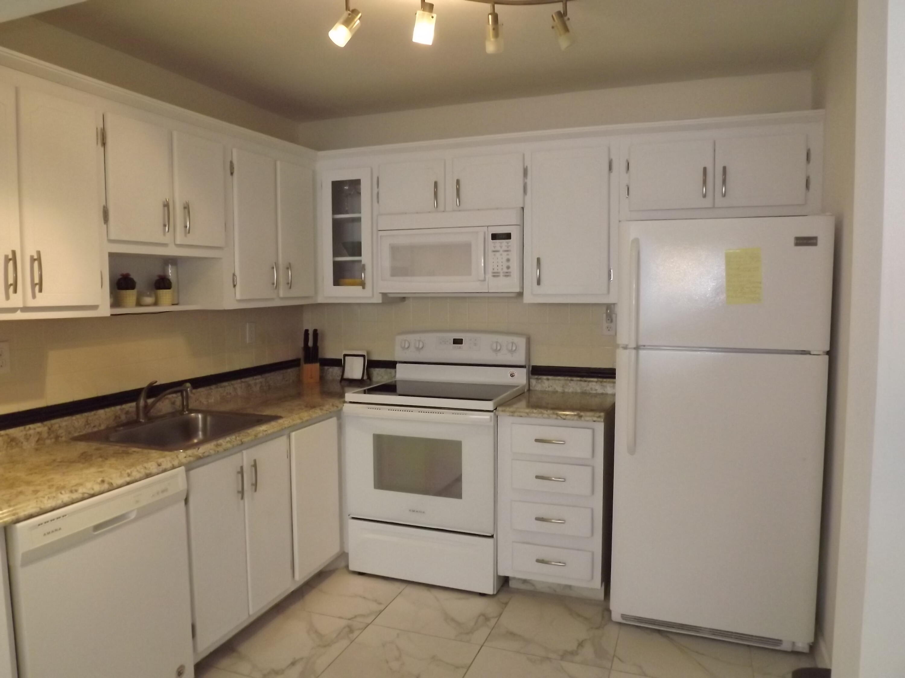 a kitchen with white cabinets and white appliances